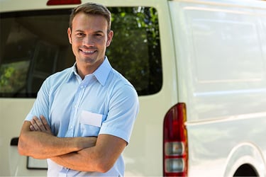 Man in blue shirt standing infront of a white truck