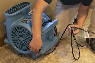 Person working with a dri-eaz dryer