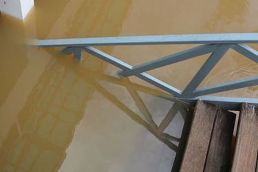 Stairs leading to a dirty flooded room. 
