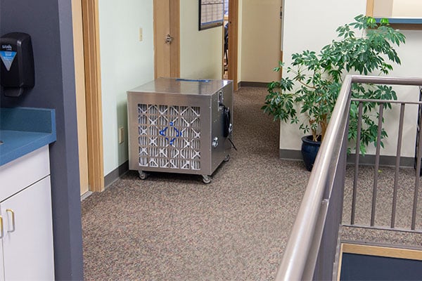 HEPA air flitration Air scrubber metal on a beige carpet in an office setting. 