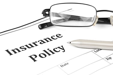 Glasses and pen sitting in an insurance policy paper