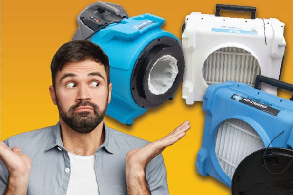 Man with hands up in front of a dri-eaz airmover, air filter, and air scrubber. 